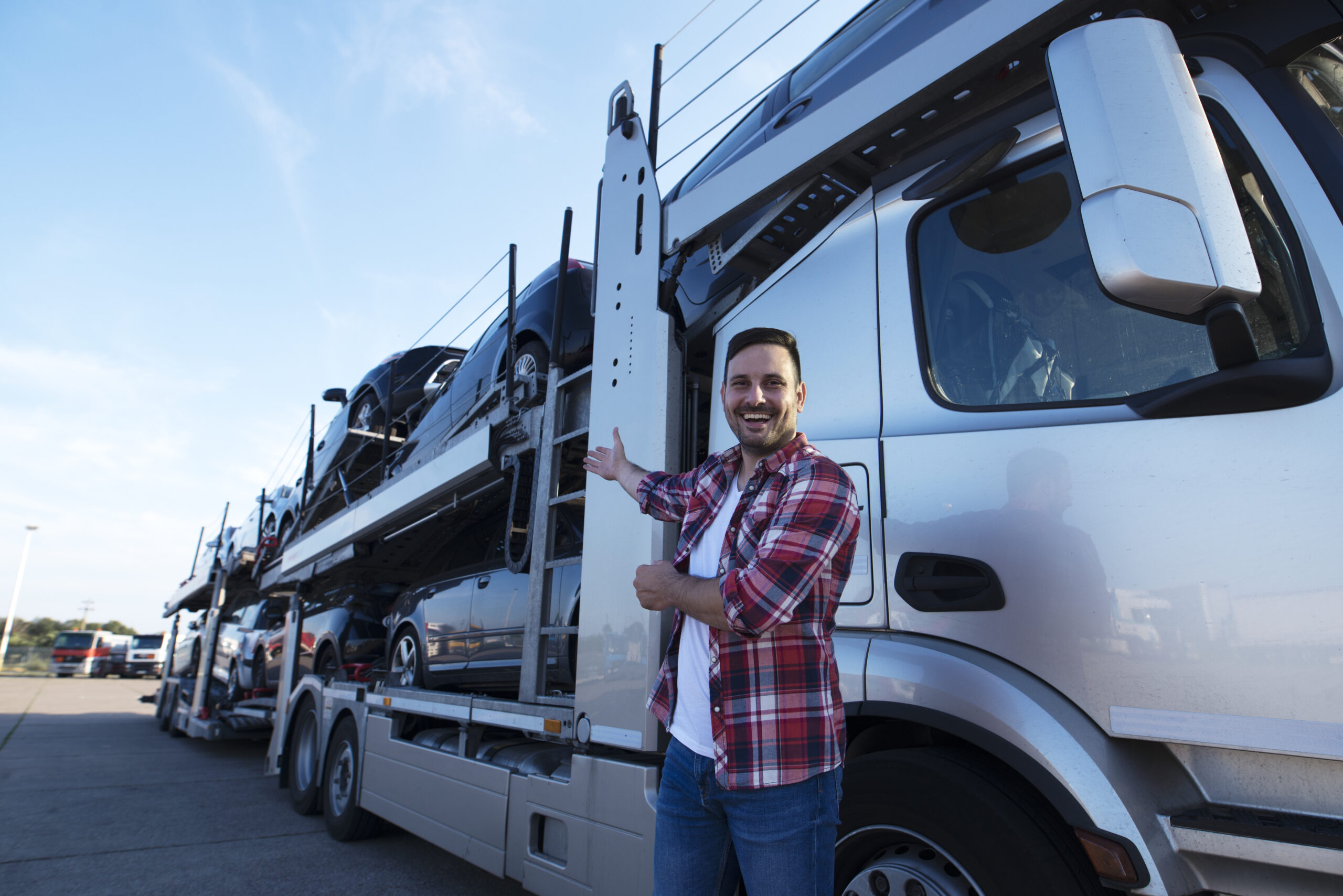 Middle Aged Trucker Front Truck Trailer With Cars 1 Scaled